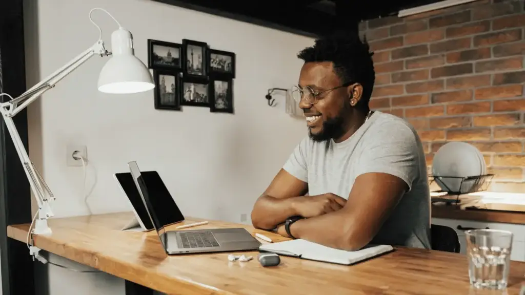 man sitting at desk looking at laptop