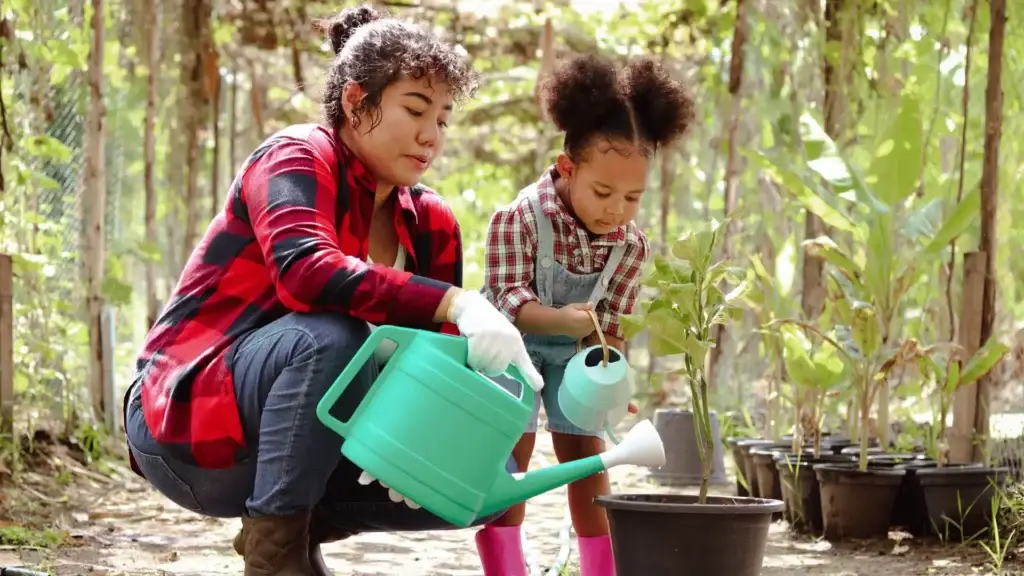 mom with daughter planting seeds in garden